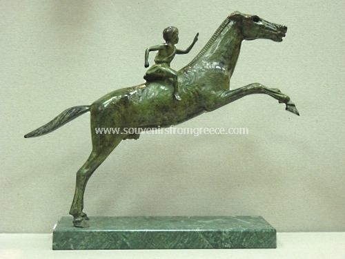 Souvenirs from Greece: Jockey of Artemision ancient greek bronze statue Greek statues Plaster statues Unique greek art souvenir from Greece handmade greek bronze statue of the Jockey of Artemision, found in pieces, in the area of a shipwreck off the cape Artemision, in north Euvea, now found in the Archeological Museum of Athens. The bronze sculpture sits on a Tinos marble base, depicts a young man riding a horse with reins in his left hand and a whip in the right. A remarkable decorative greek art gift.